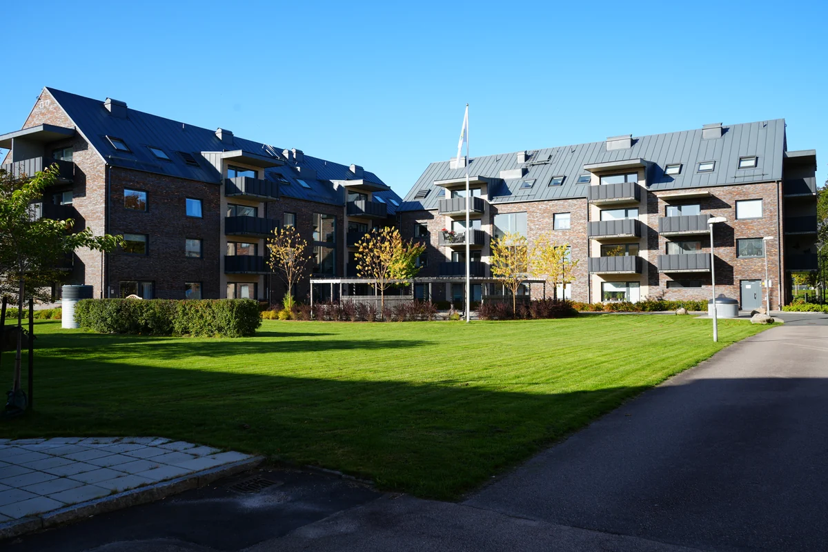 Grön gård mellan bostadshus, ur LJ Byggs bildarkiv.