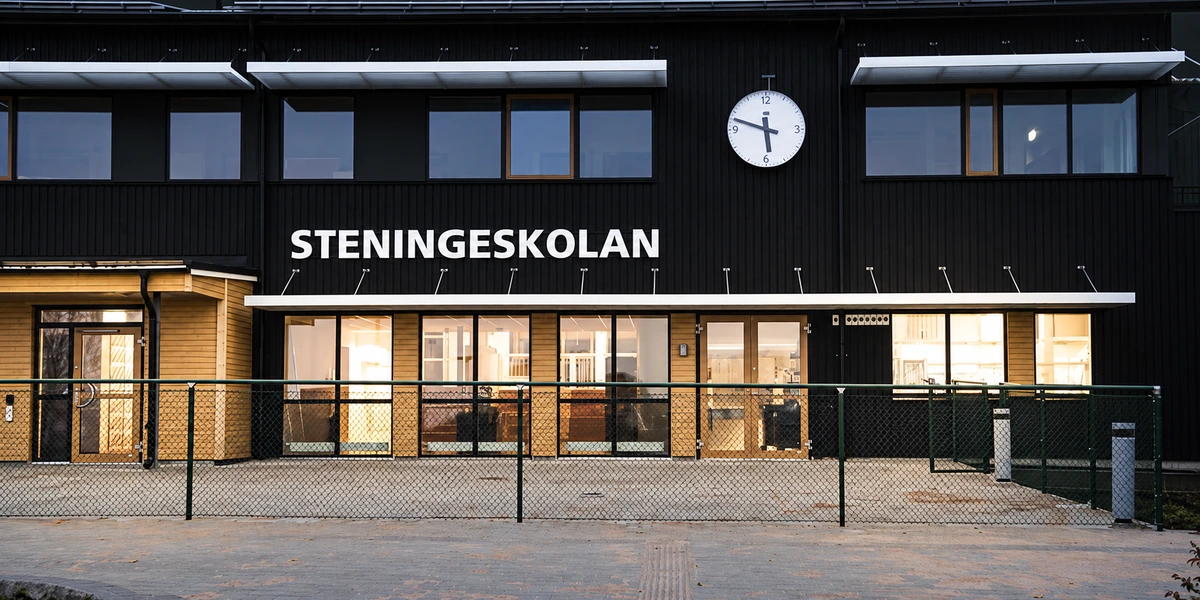 Steningeskolans entré i kvällsljus – AI-skärpt bild