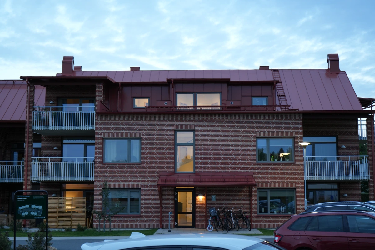 Väduren · fasaden med balkonger och en upplyst entré.